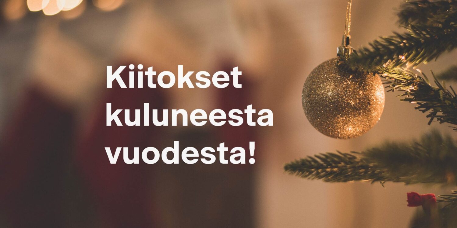 Kuvassa kiitetään kuluneesta vuodesta ja taustalla joulukuusi.